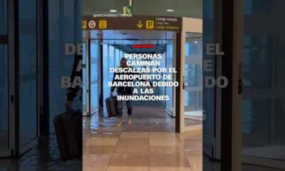 Personas caminan descalzas por el aeropuerto de Barcelona debido a las inundaciones